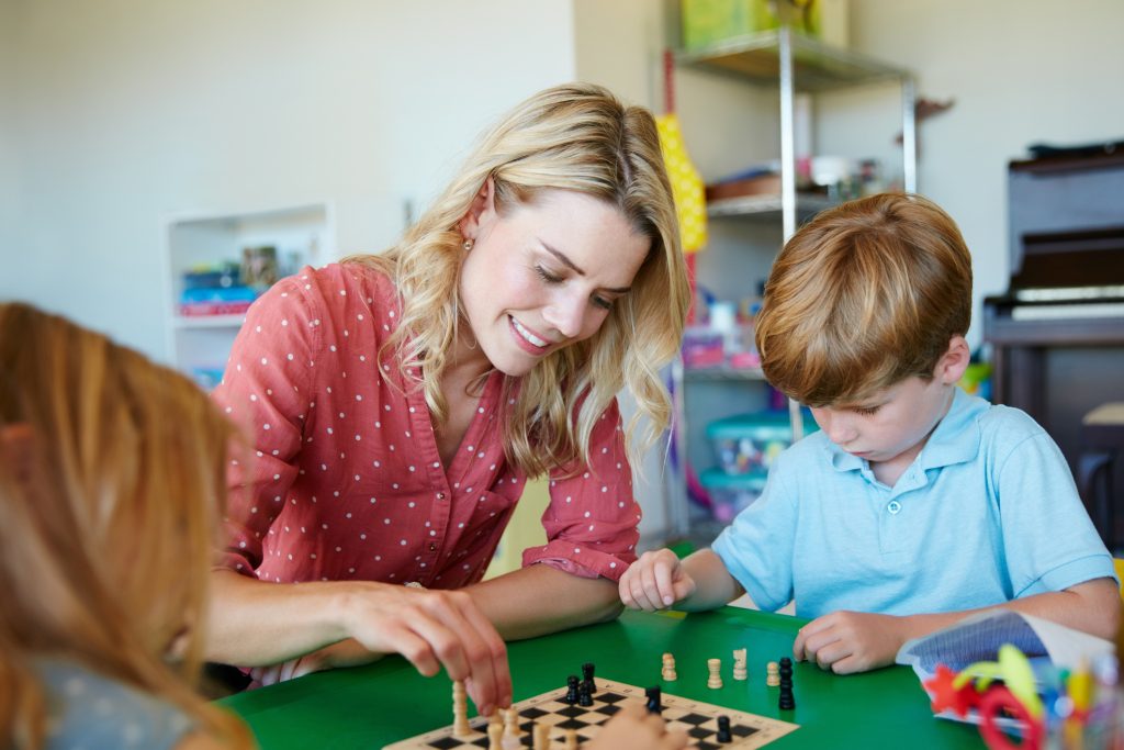 Chess instructor teaching children how to play chess