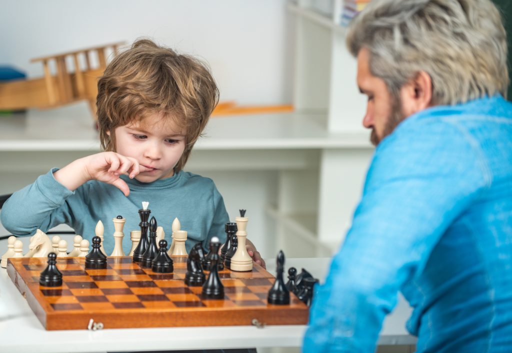Father and son playing chess at home